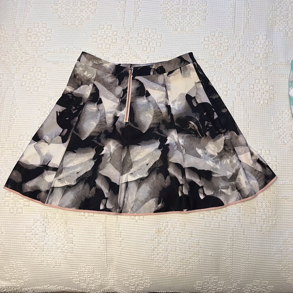 Flared short patterned skirt. with black, white, gray pattern and pink trim.